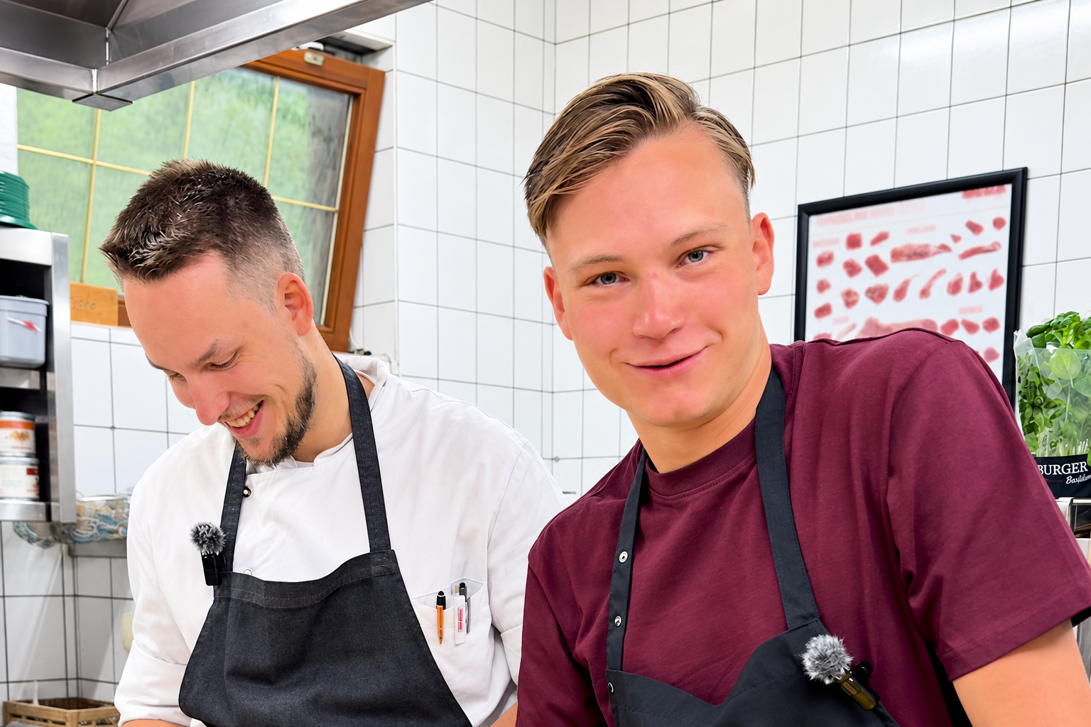 Phil und Konrad lächeln in der Küche des Restaurants.